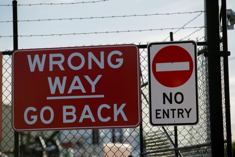 Picture of signs reading "Wrong Way | Go Back" and "No Entry"